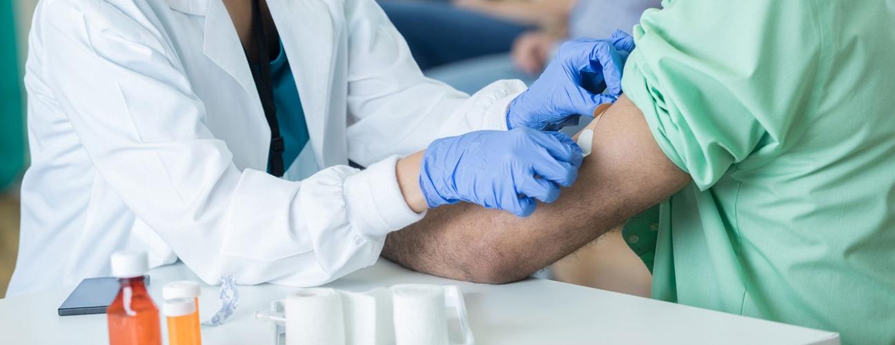 一名男子在接种疫苗后用绷带包扎手臂