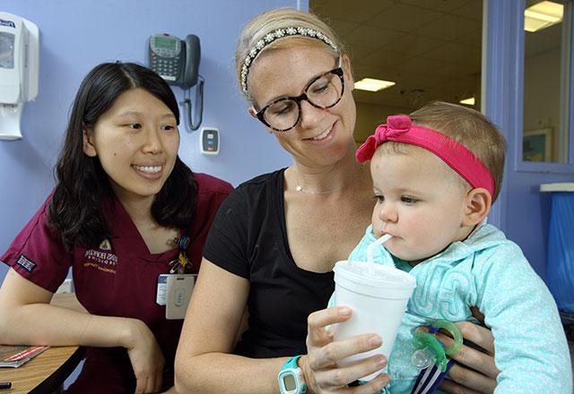 语言病理学家与婴儿和她的母亲一起研究吞咽问题
